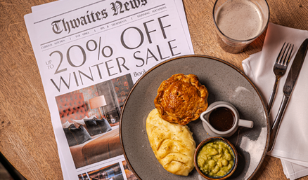 'up to 20% off' newspaper flat lay at a pub table with pie and mash
